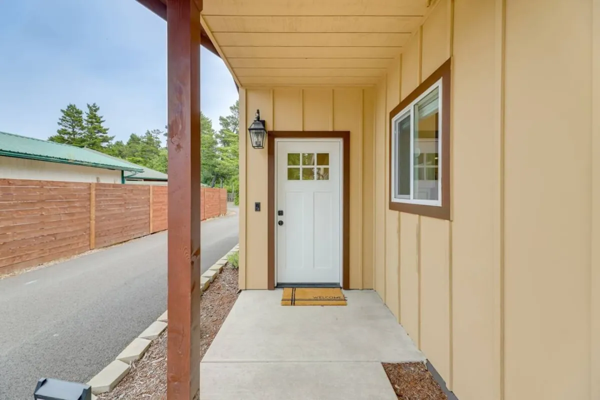 This image focuses on the front door with a welcome mat, an outdoor light fixture, and a sidewalk, creating a sense of arrival. The inviting entrance hints at the transition from outdoor adventures back to the comforts of home.