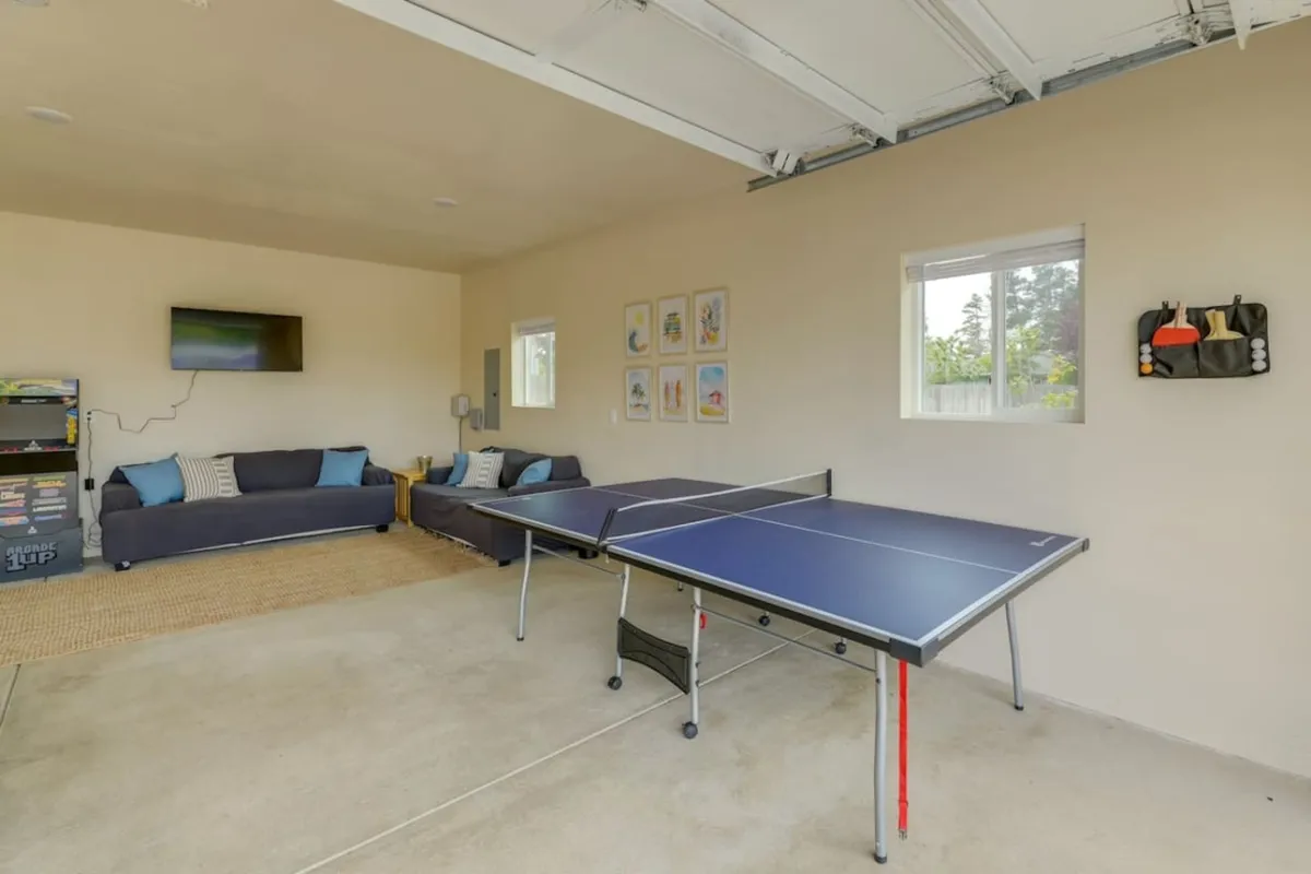 A cheerful interior game room featuring a ping pong table, comfortable sofa, and vibrant wall art. The space is designed for fun, active play, and relaxed downtime, making it ideal for families seeking entertainment after outdoor activities.