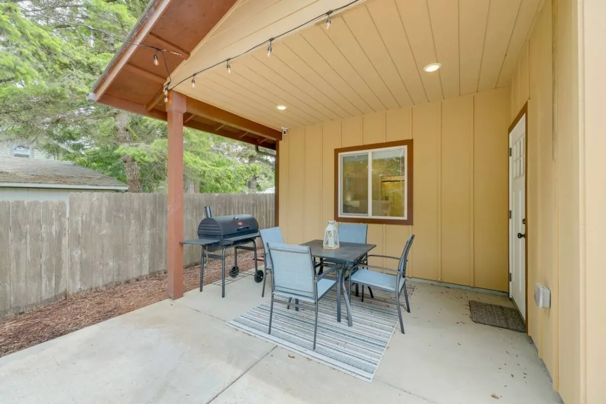 An inviting outdoor dining area with a table, grill, and decorative lantern, set against a casual exterior backdrop. The space radiates a welcoming atmosphere for group gatherings, outdoor meals, and post-adventure relaxation.